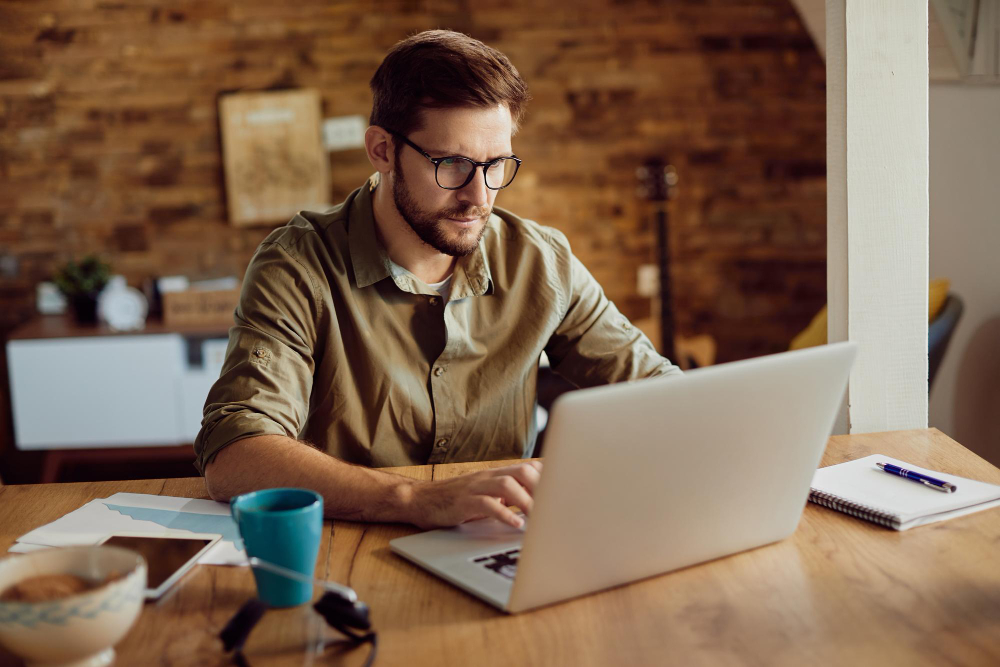 homem a trabalhar no computador em casa